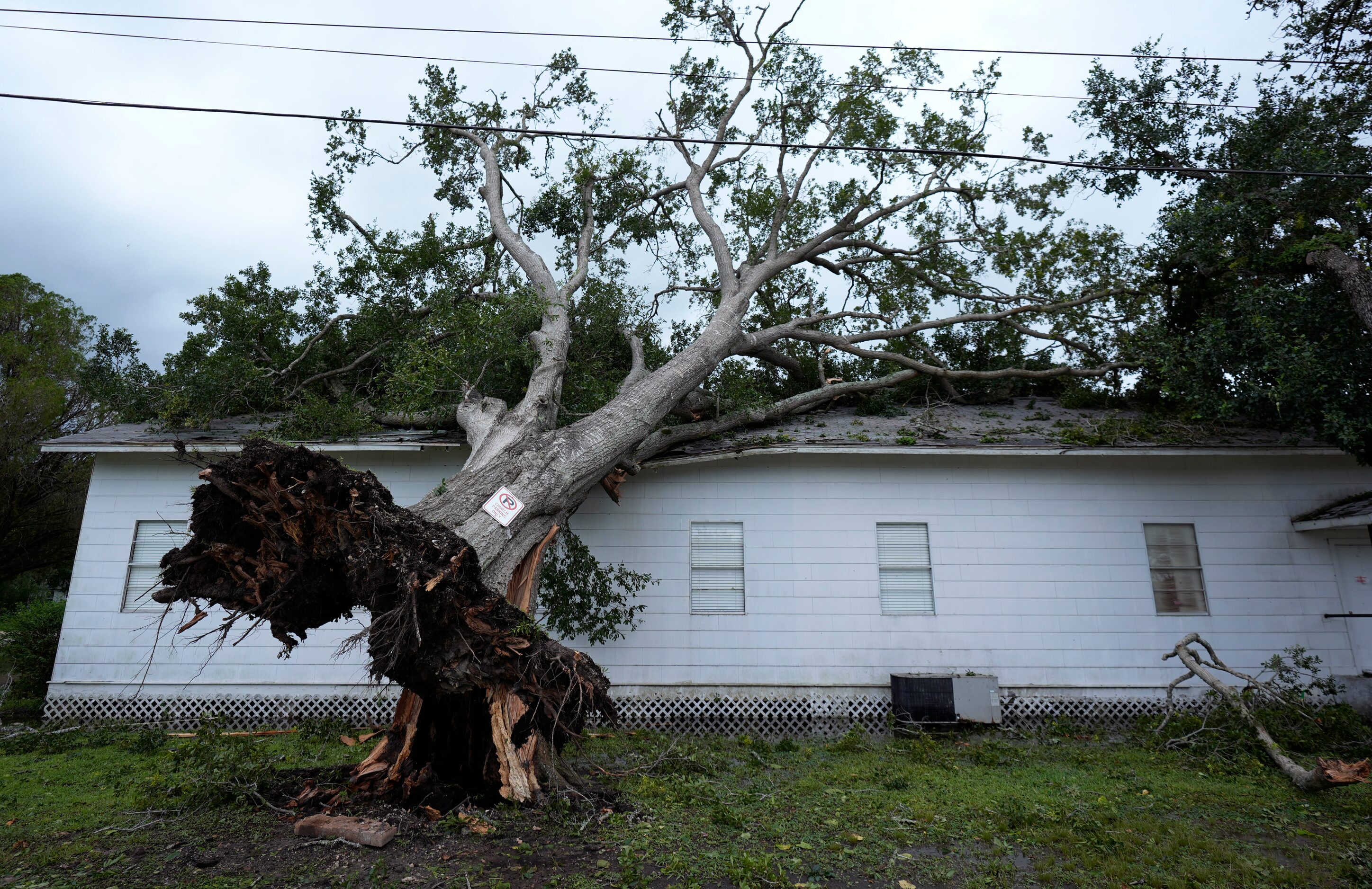 An upended tree rests on Bethel Church after Hurricane Beryl moved through the area, Monday,...