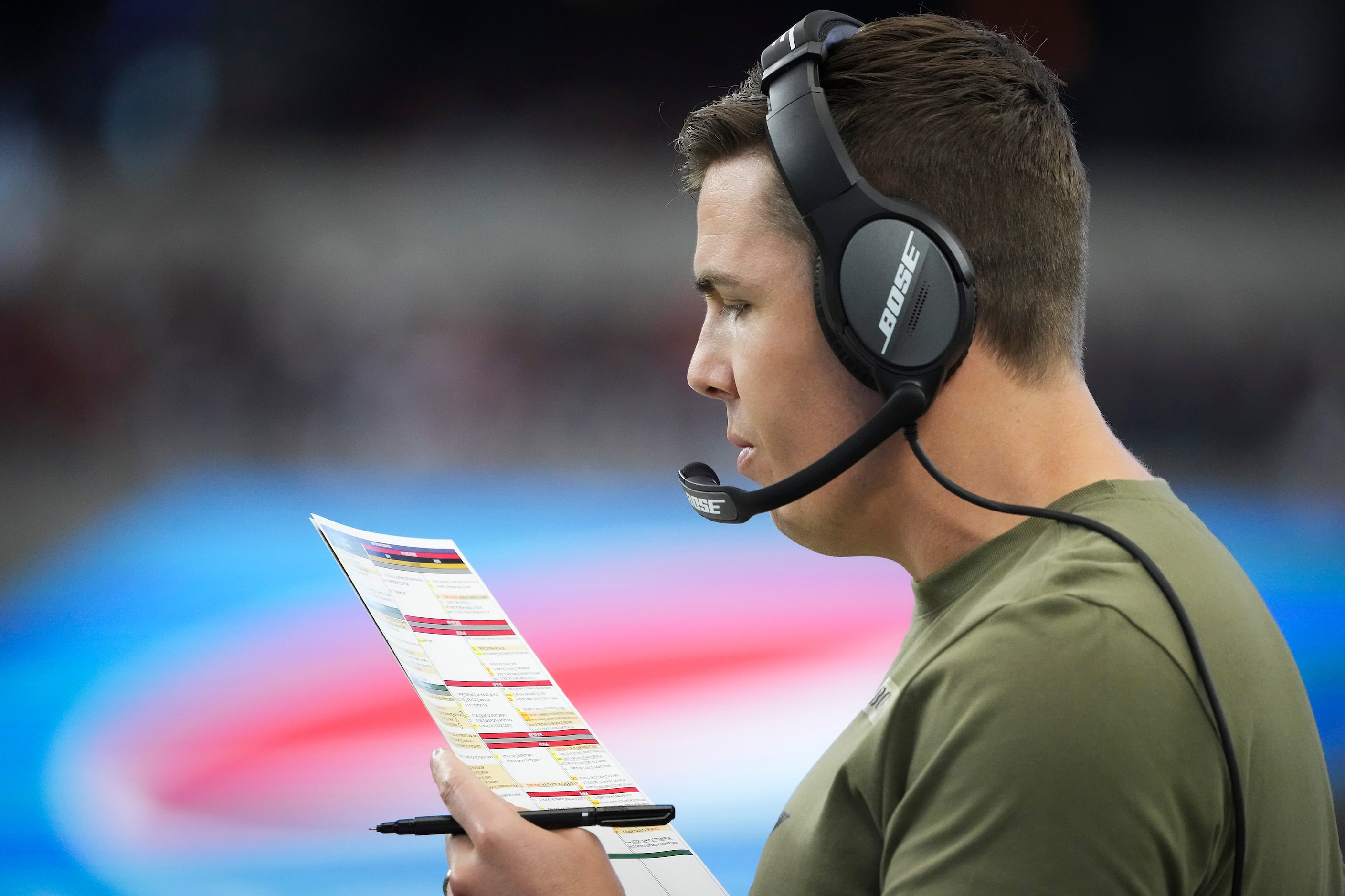 Dallas Cowboys offensive coordinator Kellen Moore works on the sidelines during the first...