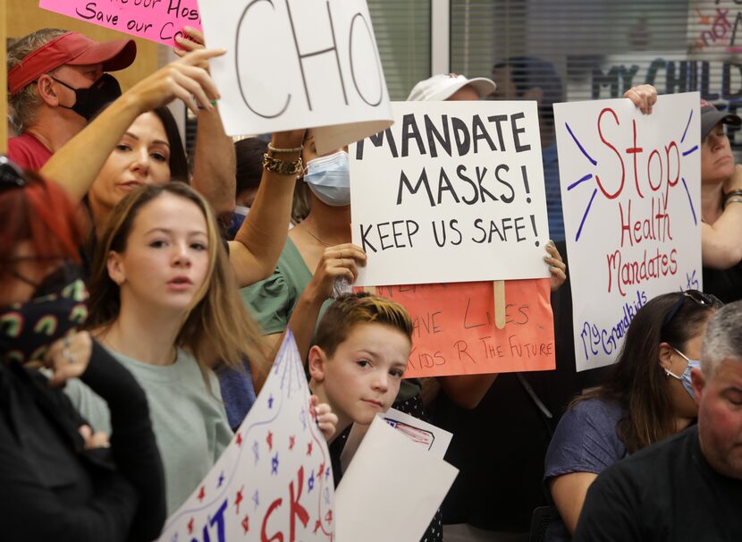 Community members on both sides of the masking debate gathered Monday during an emergency...