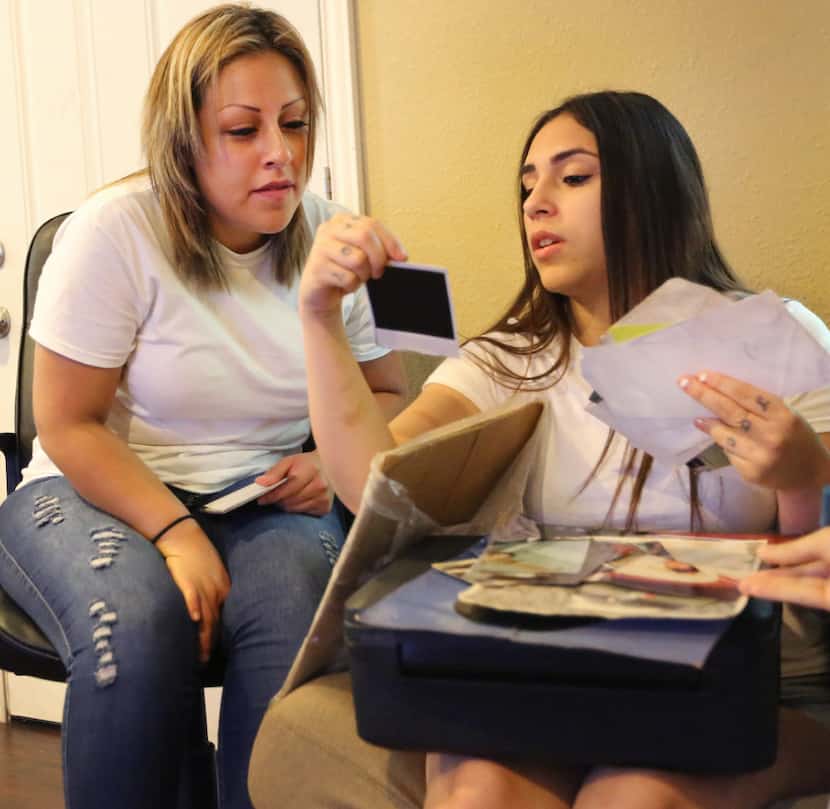 Daisy Serrano-Dominguez (right) looks at family photos with Dulce Dominguez after the...