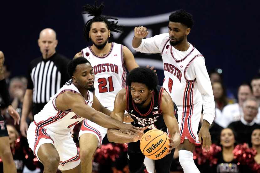 Houston guard L.J. Cryer, left, tries to steal the ball from Texas Tech guard Kerwin Walton...