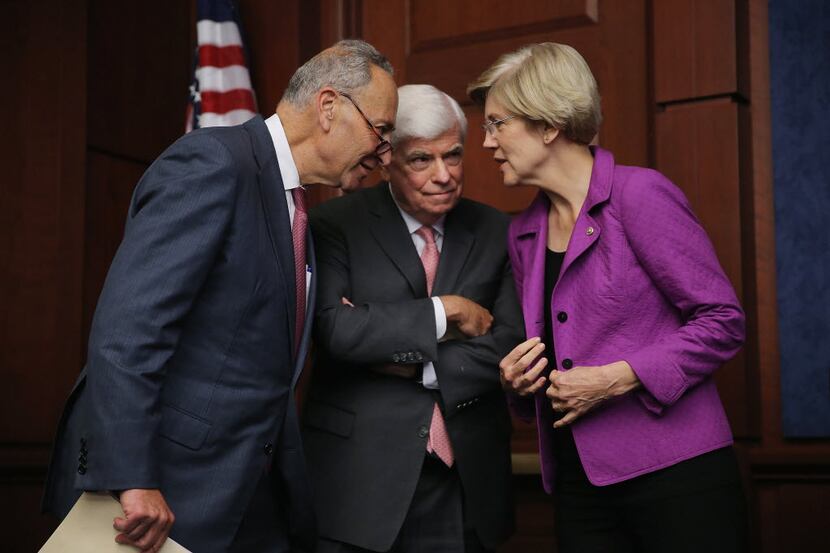 
Sens. Chuck Schumer (left) and Elizabeth Warren talk with former Sen. Chris Dodd during a...