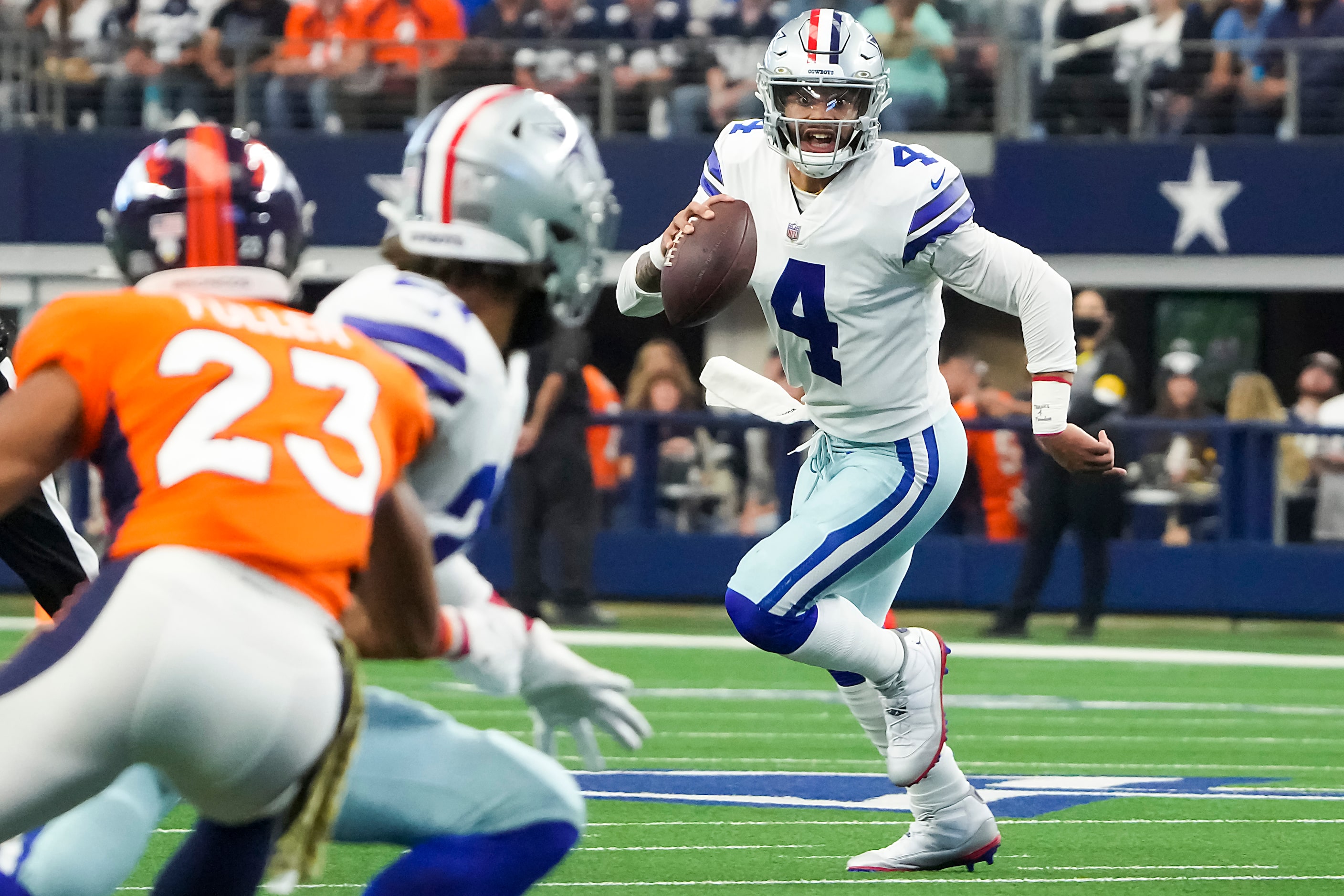 Dallas Cowboys quarterback Dak Prescott (4) scrambles out of the pocket as he eyes running...