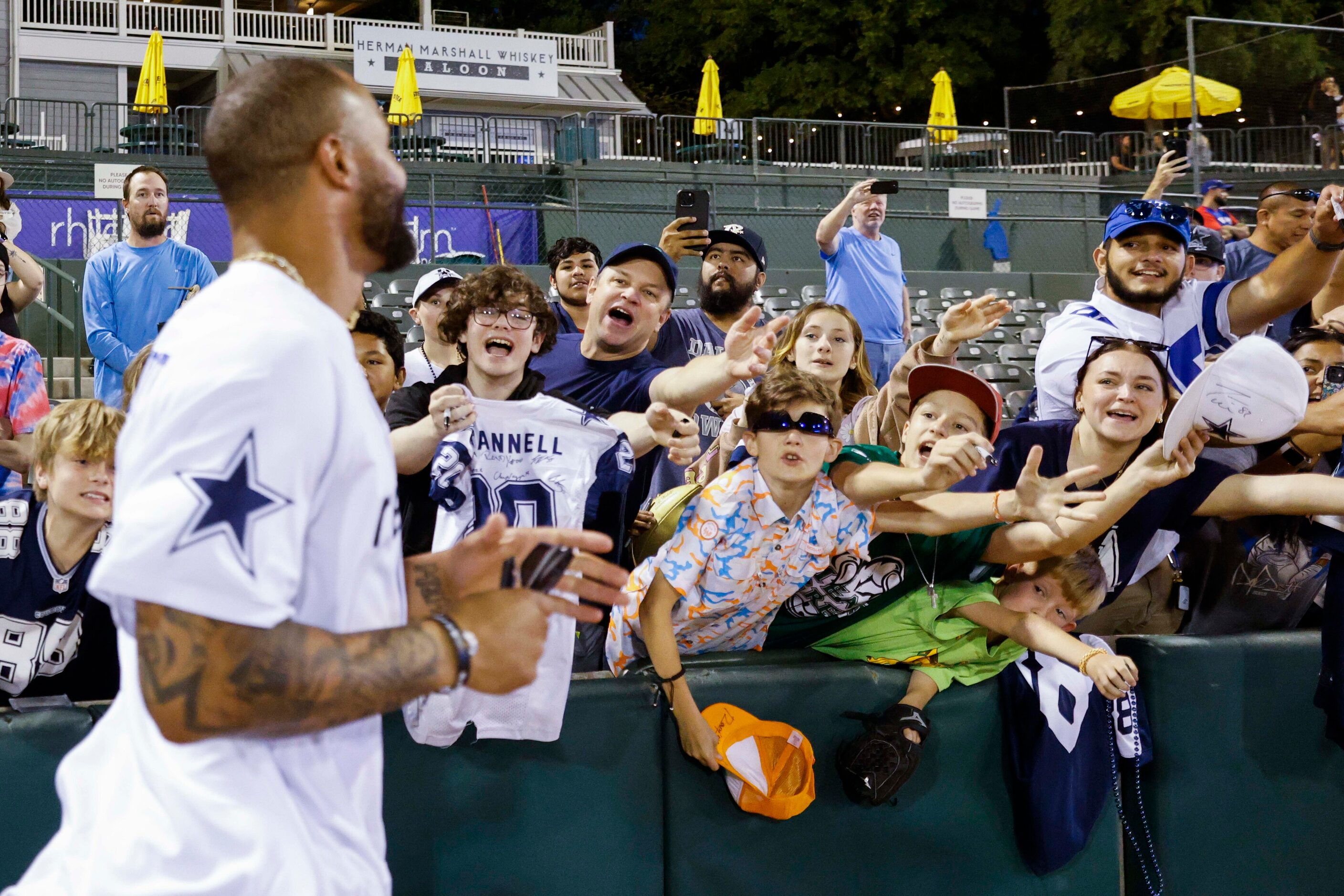 Fans cheer as Dallas Cowboys QB Dak Prescott passes by during annual home run derby on...