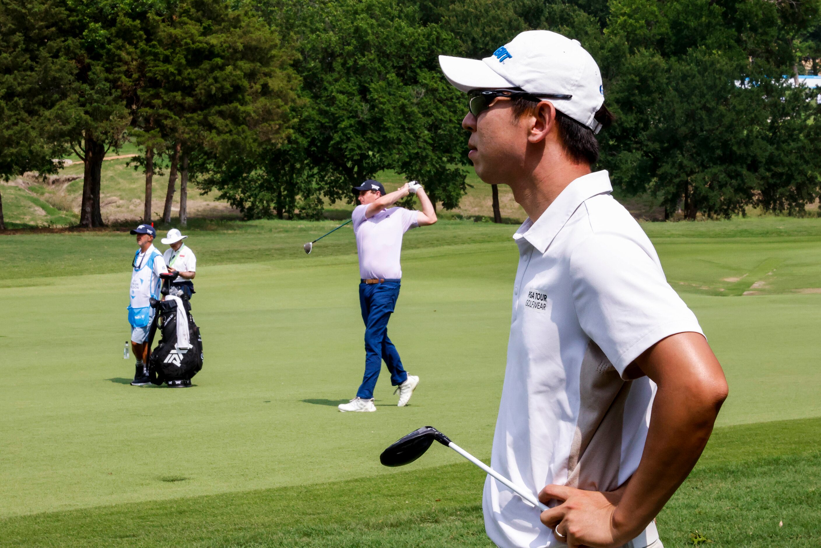 S.Y. Noh of South Korea watches as Henrik Norlander of Sweden hits from the fairway during...