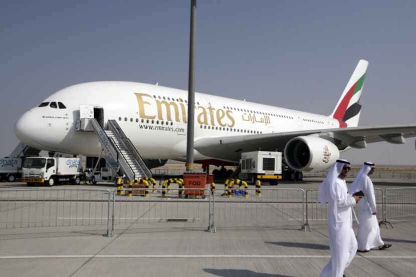 Visitors walk past the Emirates Airline Airbus A380 aircraft as it sits on static display...