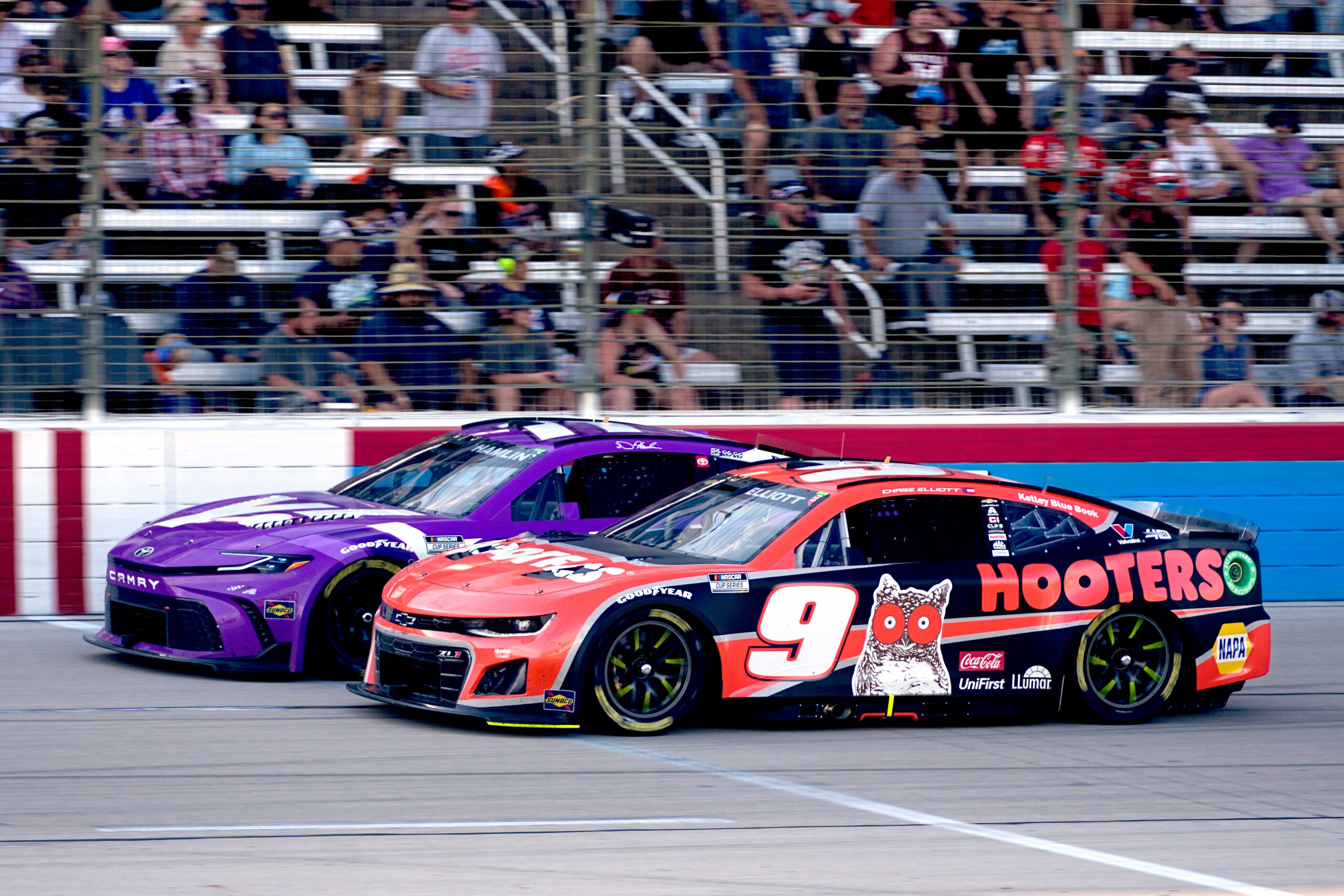 Chase Elliott (9) and Denny Hamlin, left, come out of Turn 4 in the final laps of a NASCAR...