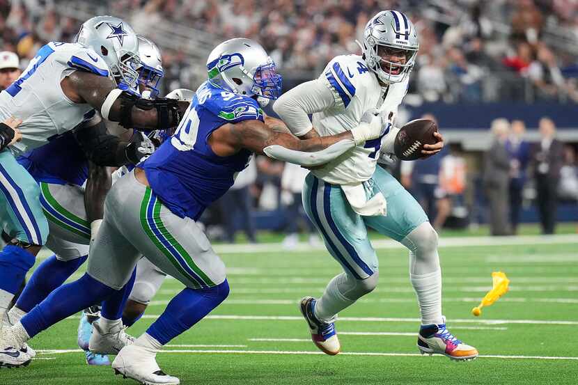 Dallas Cowboys quarterback Dak Prescott (4) is sacked by Seattle Seahawks defensive end...
