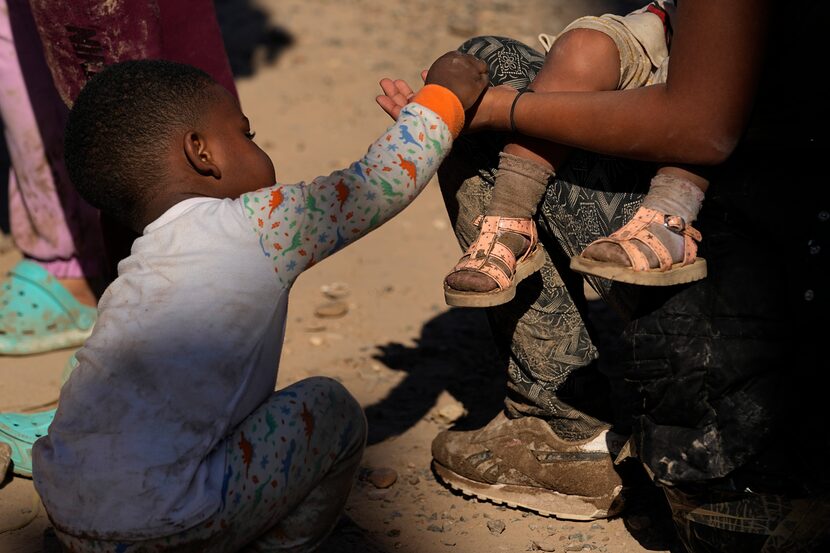 Migrants wait to be processed by the U.S. Customs and Border Patrol after they crossed the...