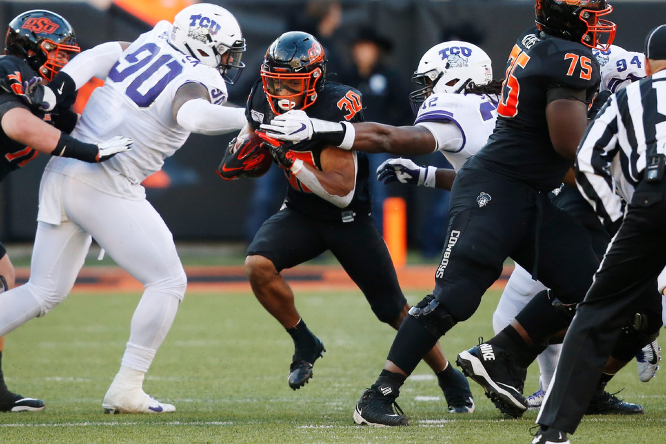 Oklahoma State running back Chuba Hubbard (30) breaks through the TCU line past defensive...