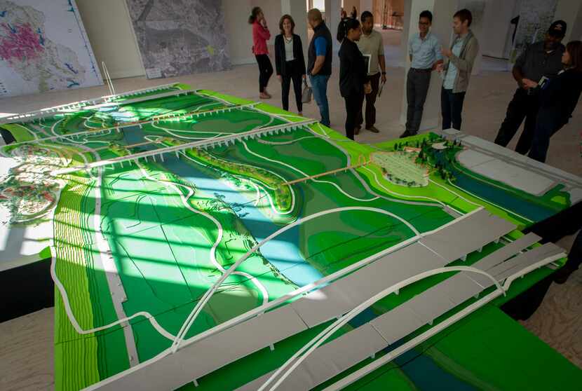 Visitors look at a model of Harold Simmons Park on exhibit at at Old Dallas High School in...