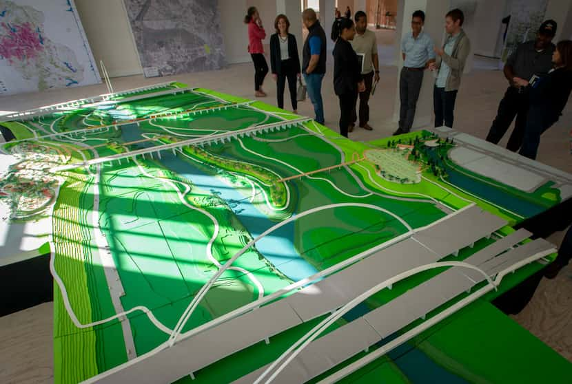 Visitors look at a model of Harold Simmons Park on exhibit at at Old Dallas High School in...