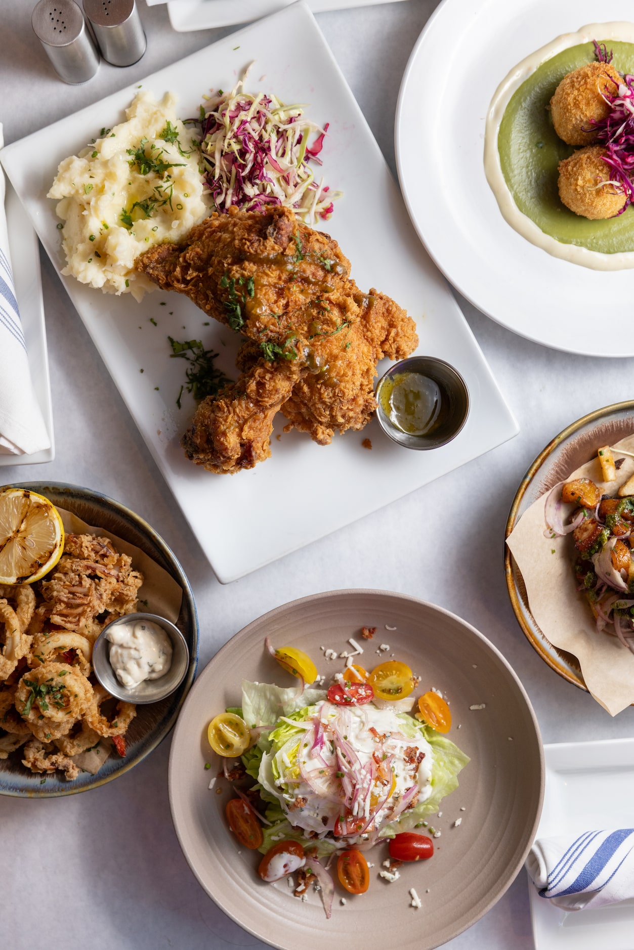 Crispy fried chicken, crab croquettes and the classic wedge salad are on the menu at Pesca...