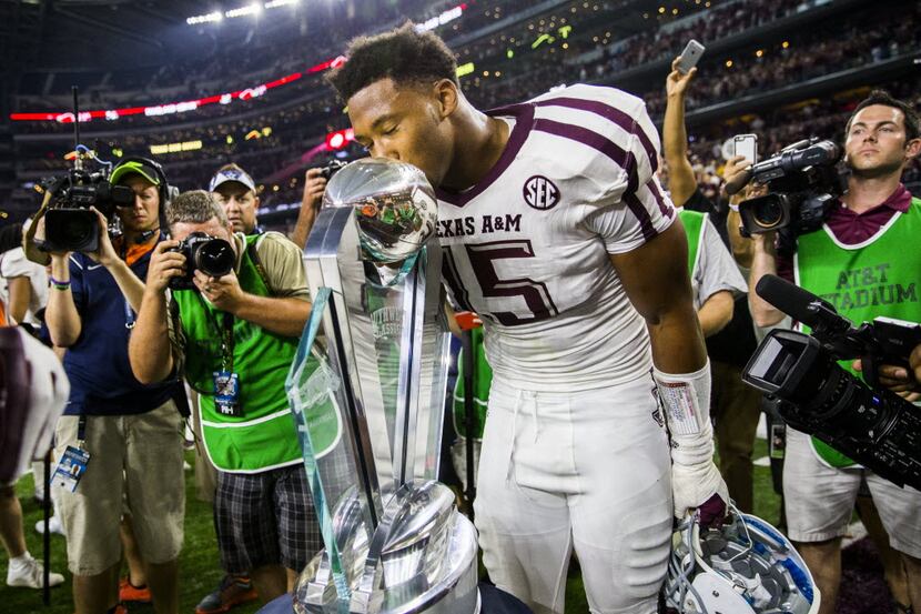 Texas A&M Aggies defensive end Myles Garrett (15) kisses a trophy after a 28-21 win over the...