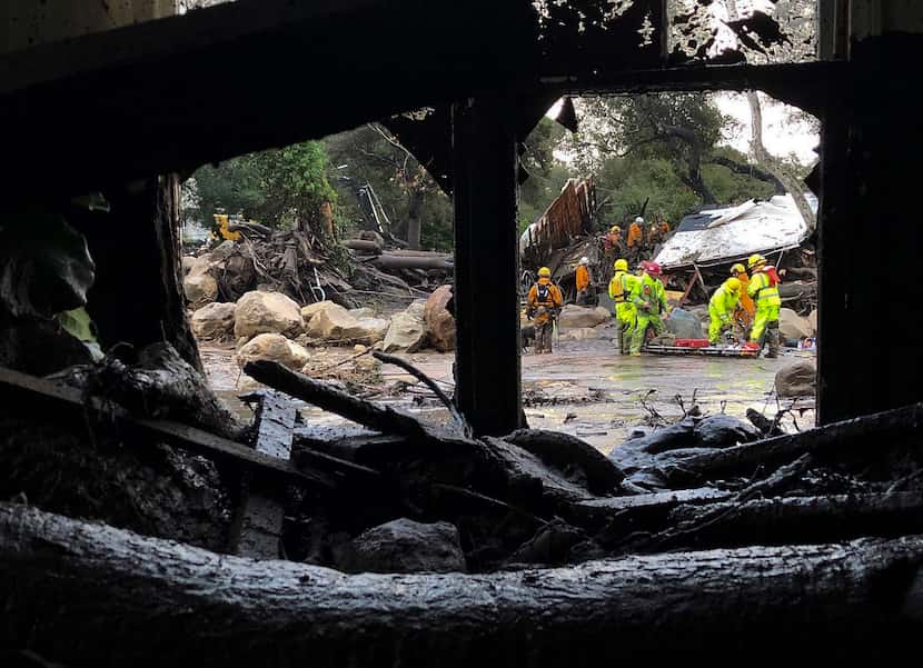 In a Santa Barbara County Fire Department photo, emergency workers look through debris of...