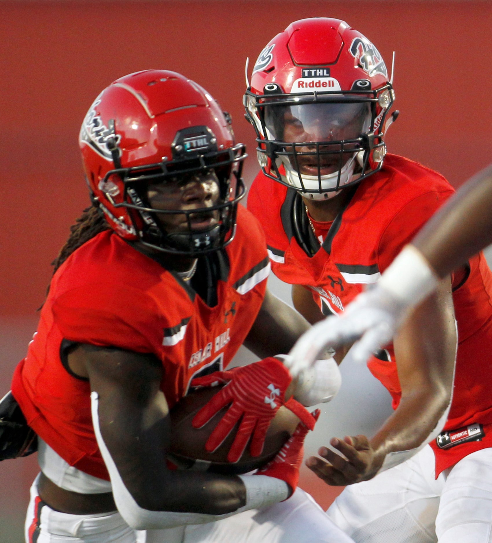 Cedar Hill quarterback Cedric Harden (5), right, hands off to running back Robert Richardson...