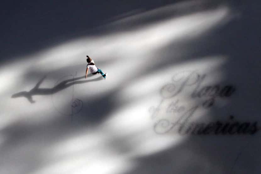 Sun streams into the atrium as a lone skater makes her way across the ice at the Plaza of...