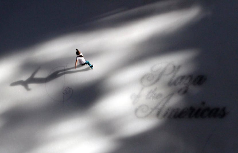 Sun streams into the atrium as a lone skater makes her way across the ice at the Plaza of...