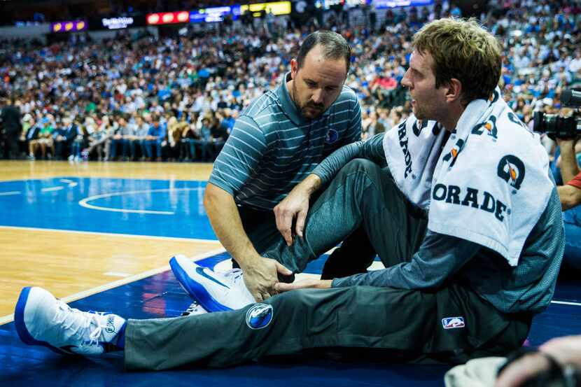 Dallas Mavericks forward Dirk Nowitzki (41) has his right achilles tendon looked at by a...