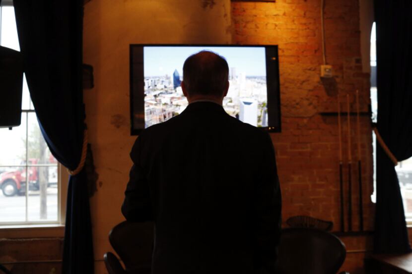 Jim Bass watches pictures of the Trinity River flash by on a screen at a symposium hosted by...