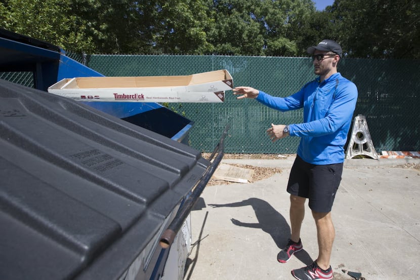 Eric Gibbs, of Dallas, tosses recyclable waste in to a Dallas Sanitation Services Department...