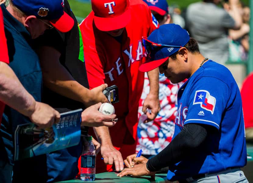 Texas Rangers right fielder Shin-Soo Choo (17) signs autographs for fans before a spring...
