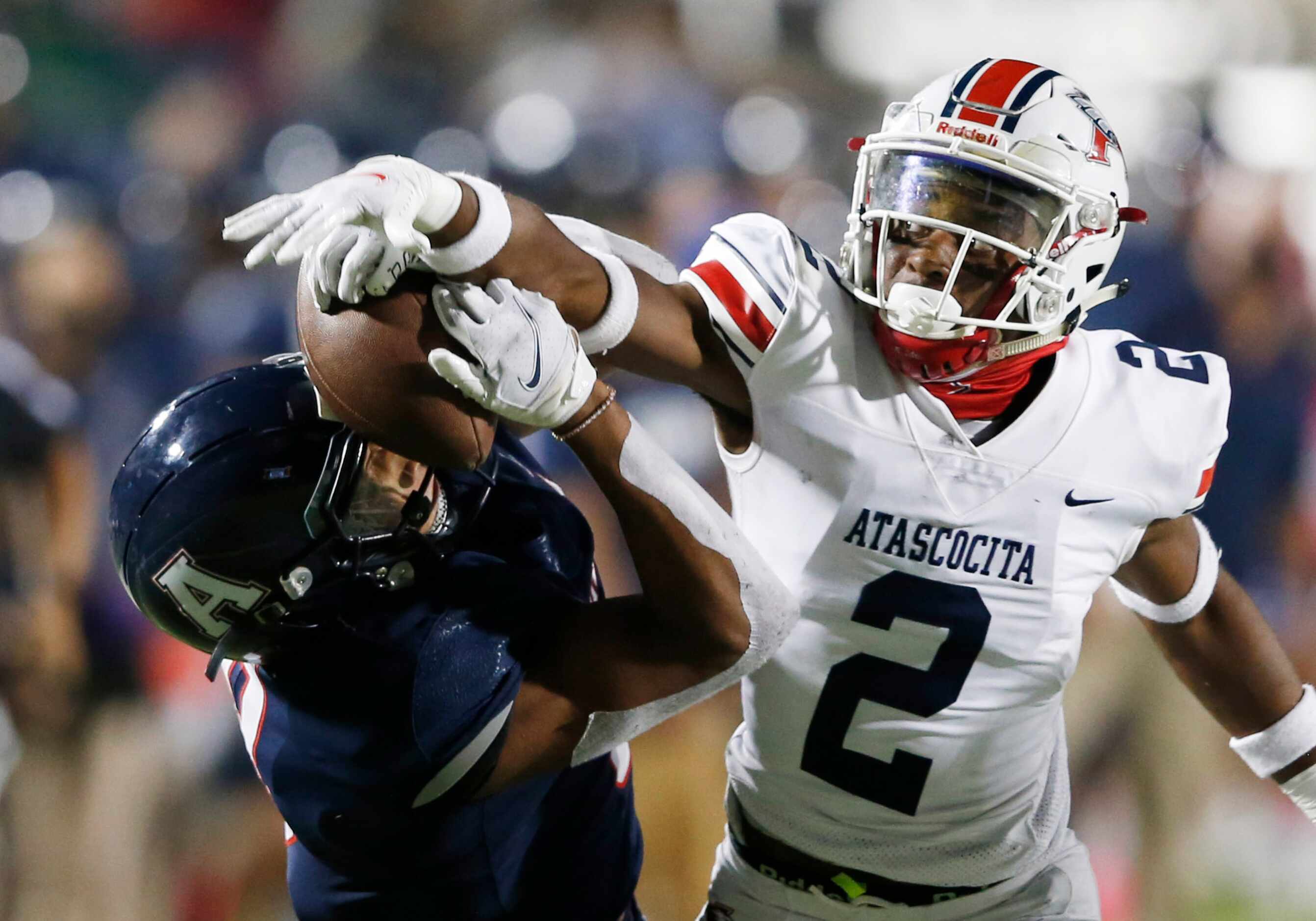 Allen's Blaine Green (8) gets the ball knocked out of his hands by Humble Atascocita's Caleb...