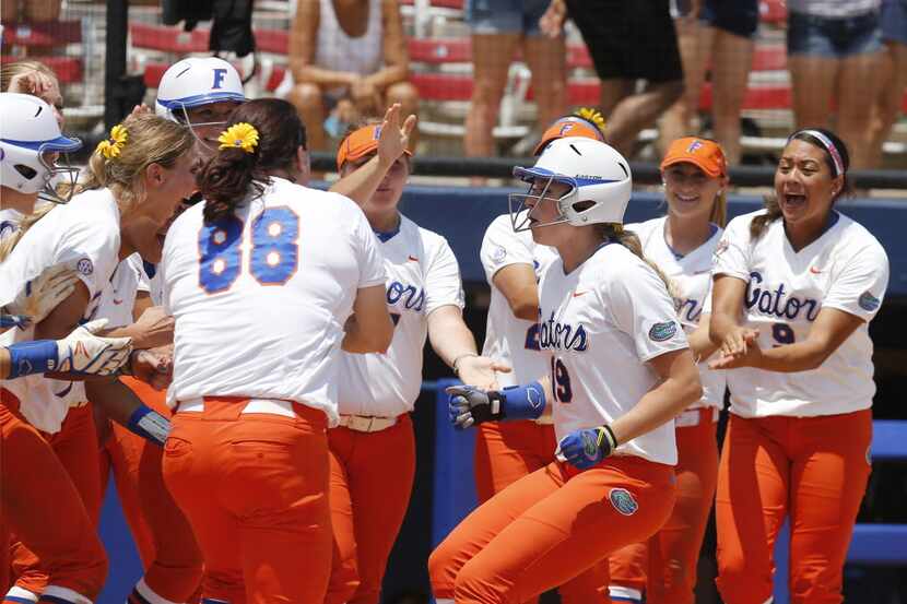 Florida's Chelsea Herndon (19) is greeted at home plate by her teammates after hitting a...