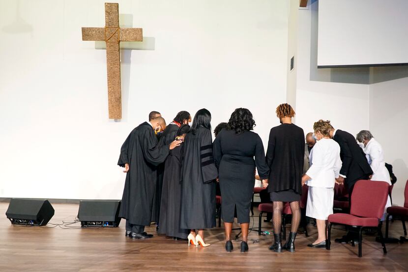 The worship team prays before the Sunday morning service began at Church of the Disciple...