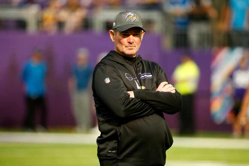 Minnesota Vikings head coach Mike Zimmer stands on the field before an NFL football game...