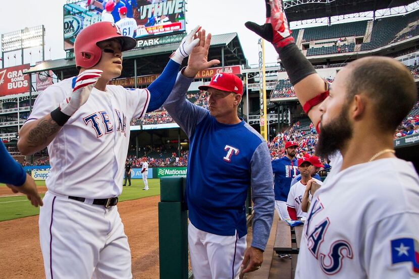 Texas Rangers designated hitter Shin-Soo Choo celebrates with manager Jeff Banister and...