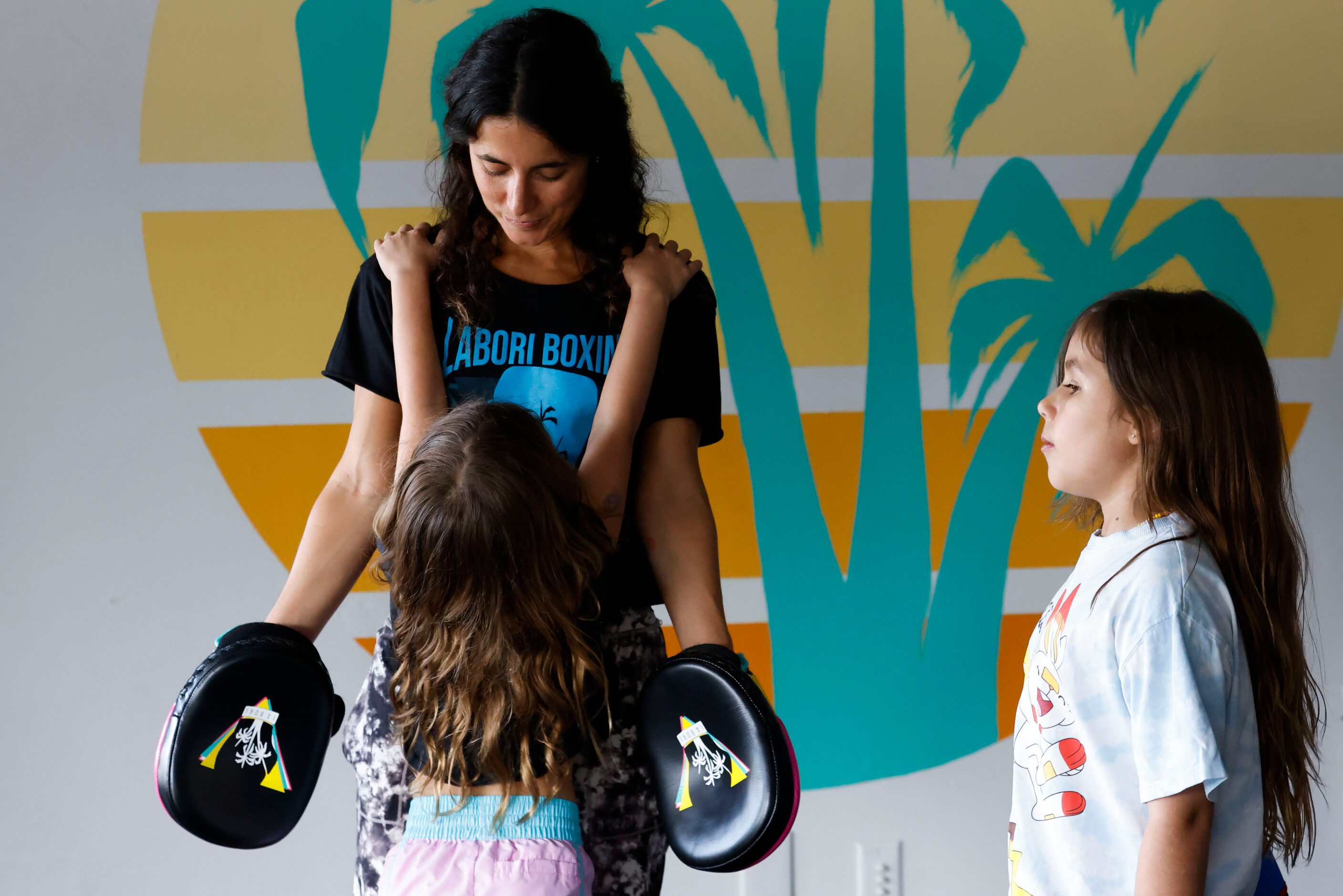 Amanda Alvarez, a salsa teacher and boxing lover, listens to her daughter Lucia, 6, (front)...