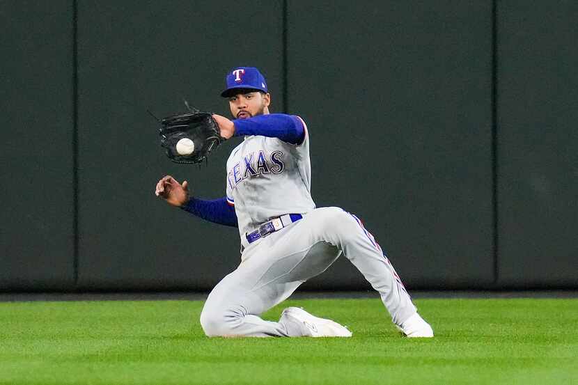 Texas Rangers center fielder Leody Taveras makes a sliding catch on a line drive by...