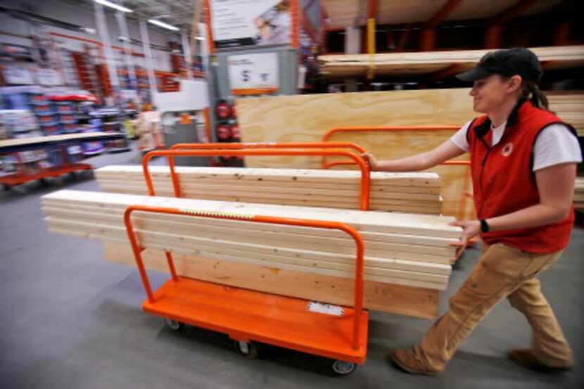 Una clienta empuja una plataforma móvil con madera en Home Depot (AP /Gene J. Puskar)