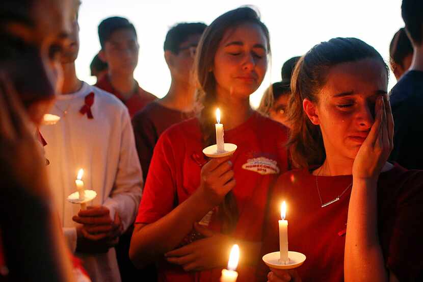 In this February, 2017, students gather to grieve during a vigil at Pine Trails Park for the...