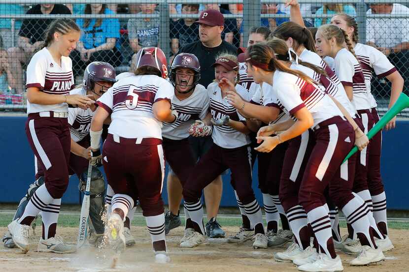 Plano designated player Bronte Rhoden (5) trots into home surrounded by her team after...