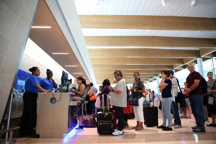 Passengers wait in line at the Southwest Airlines terminal at Dallas Love Field Airport in...