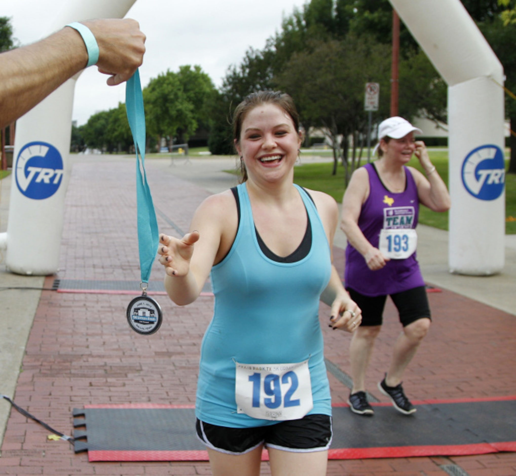 Danita Chappell, left, grabs her medal as she crosses the finish line with her mother...