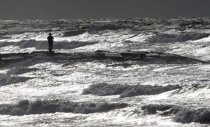 Rich Banks stands along a jetty as he takes photos of the oncoming waves in the Gulf of...