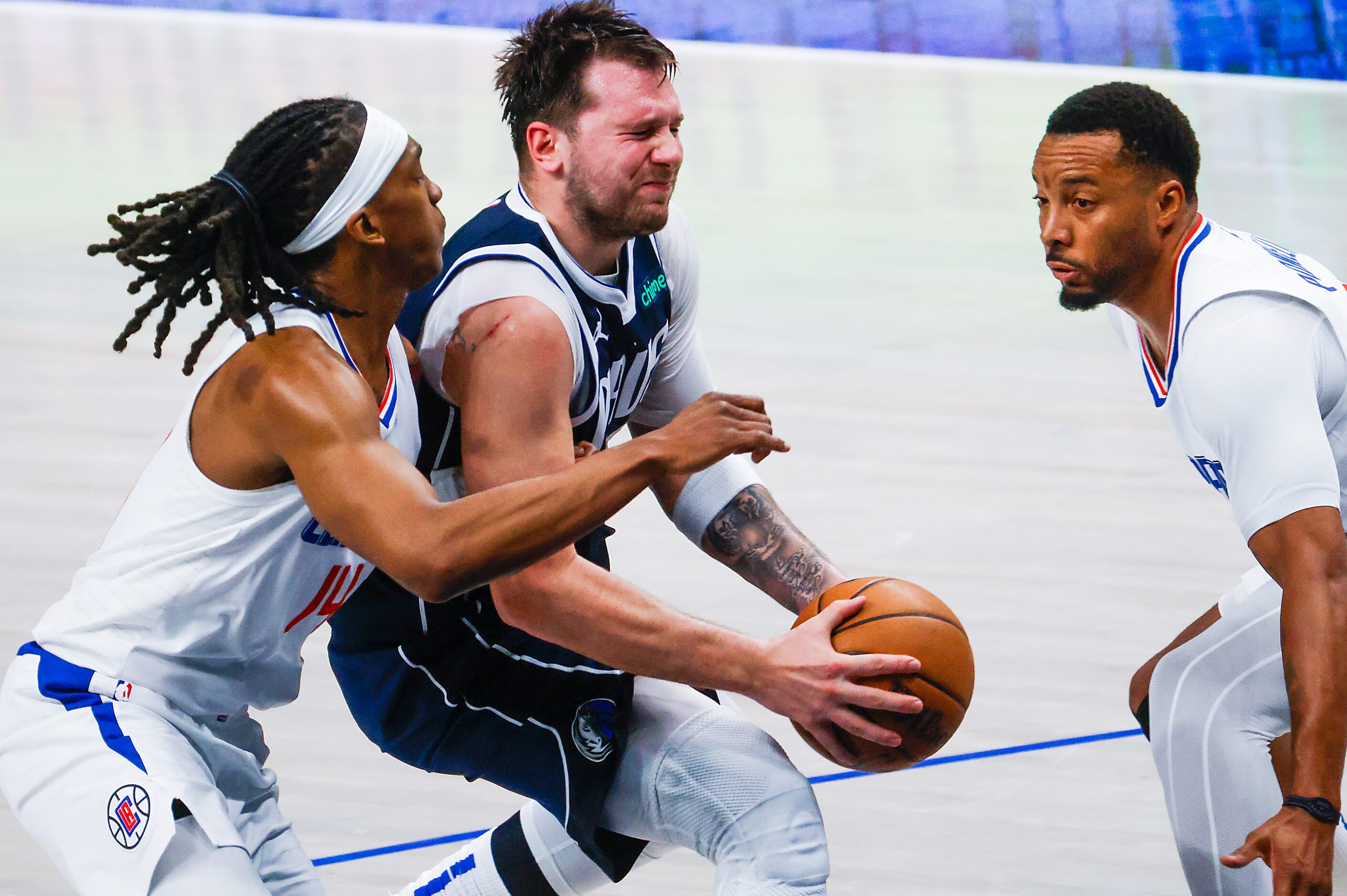 Dallas Mavericks guard Luka Doncic (center) tries to get past LA Clippers guard Terance Mann...