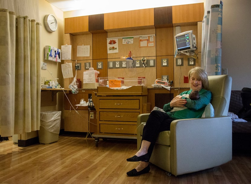 Volunteer Beverley Denman cradles Anthony Gonzalez at Texas Health Presbyterian Hospital...