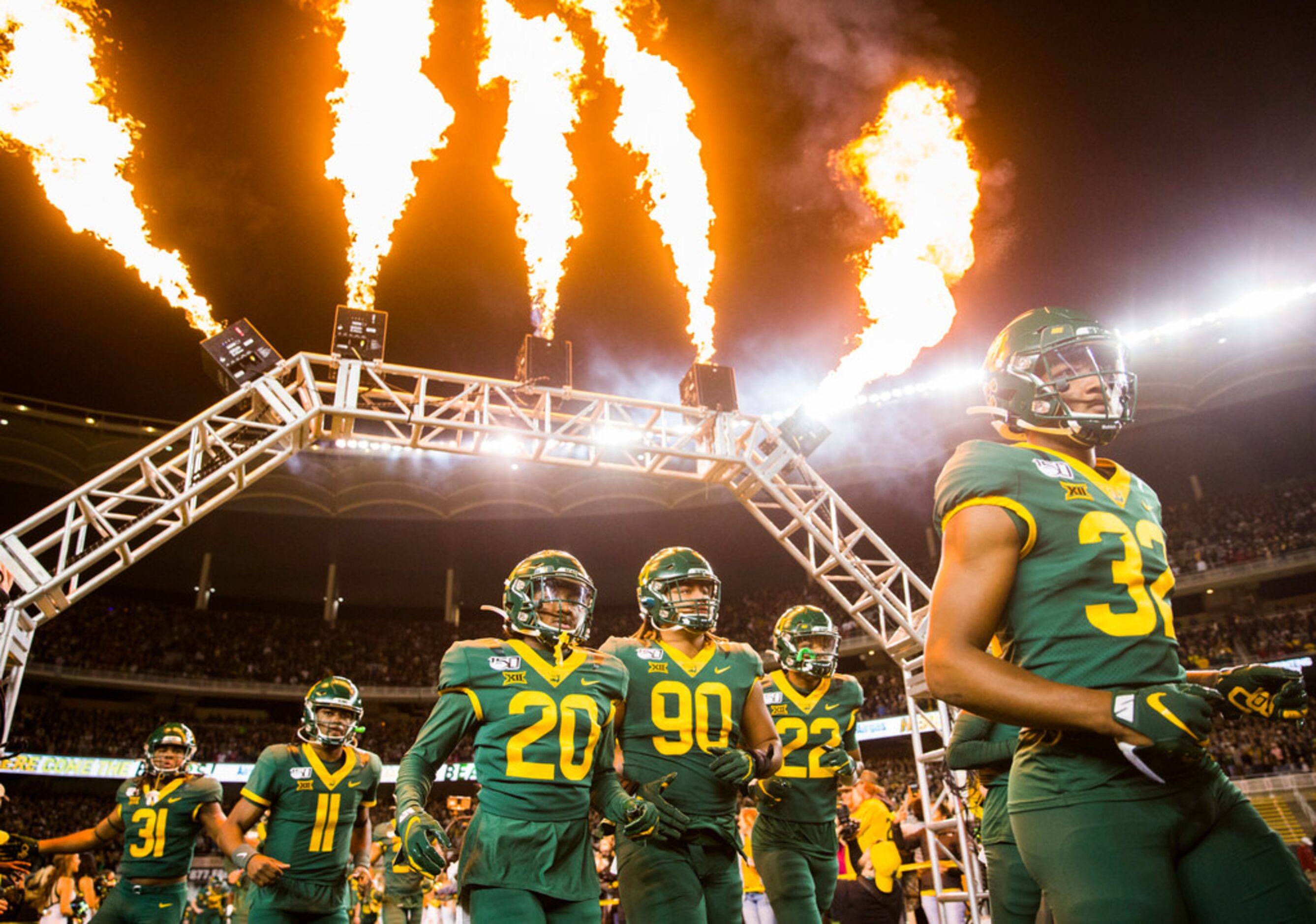 Baylor Bears football players run on the field before an NCAA football game between Baylor...