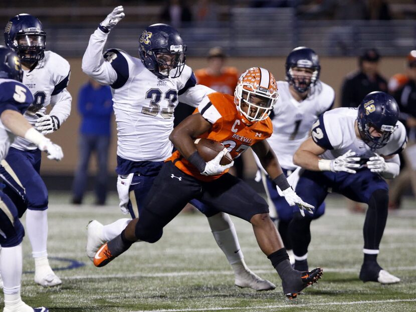 (TXHSFB) Rockwall RB Caleb Broach (27) eludes a group of Jesuit defenders, including Jordan...