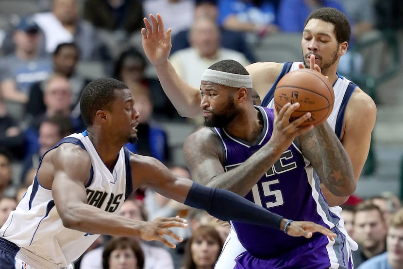 DeMarcus Cousins #15 of the Sacramento Kings drives to the basket against Harrison Barnes...