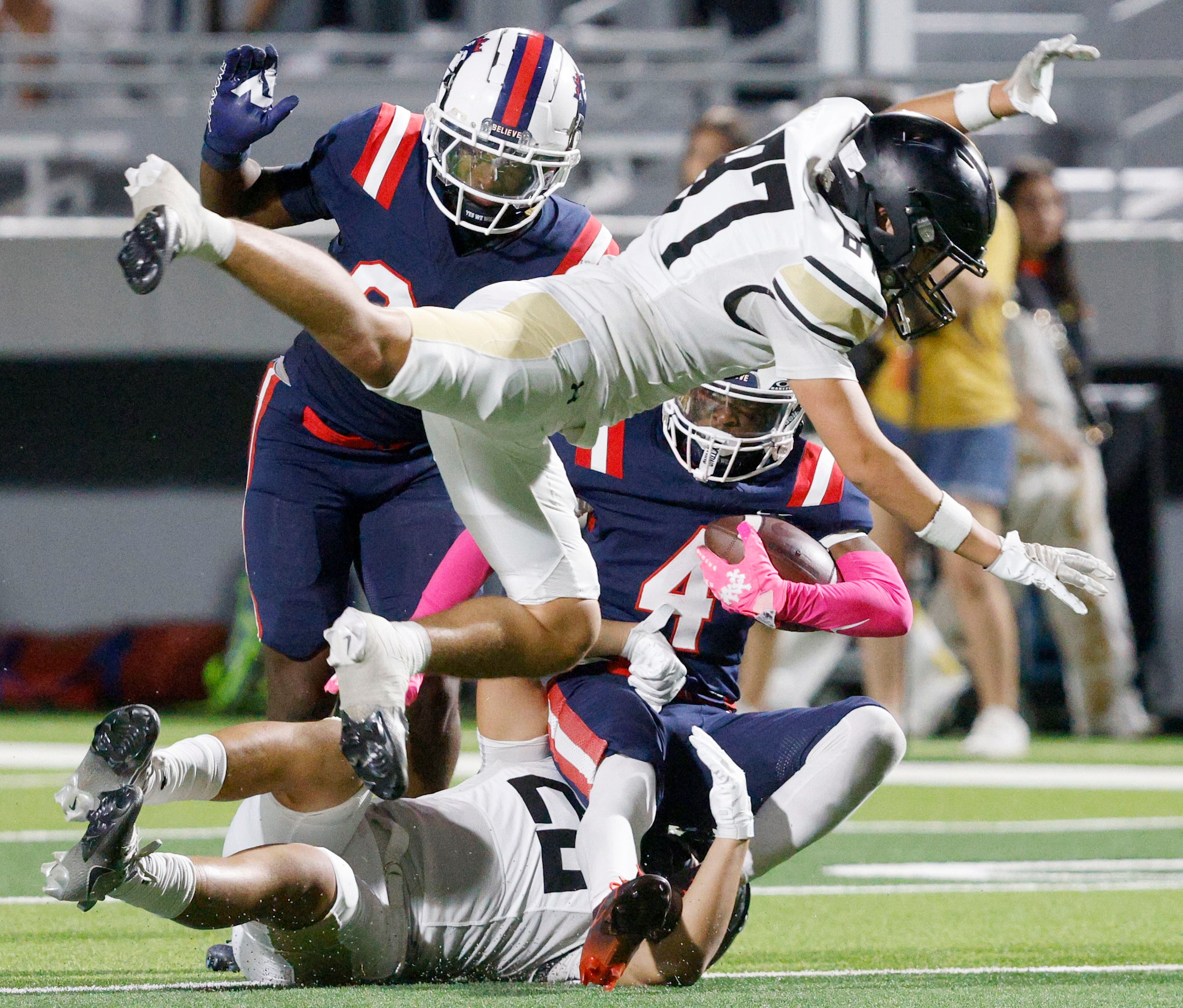 Richland's Deon Jones (4), background right, is tackled by Fossil Ridge's Bentley Thao (20),...