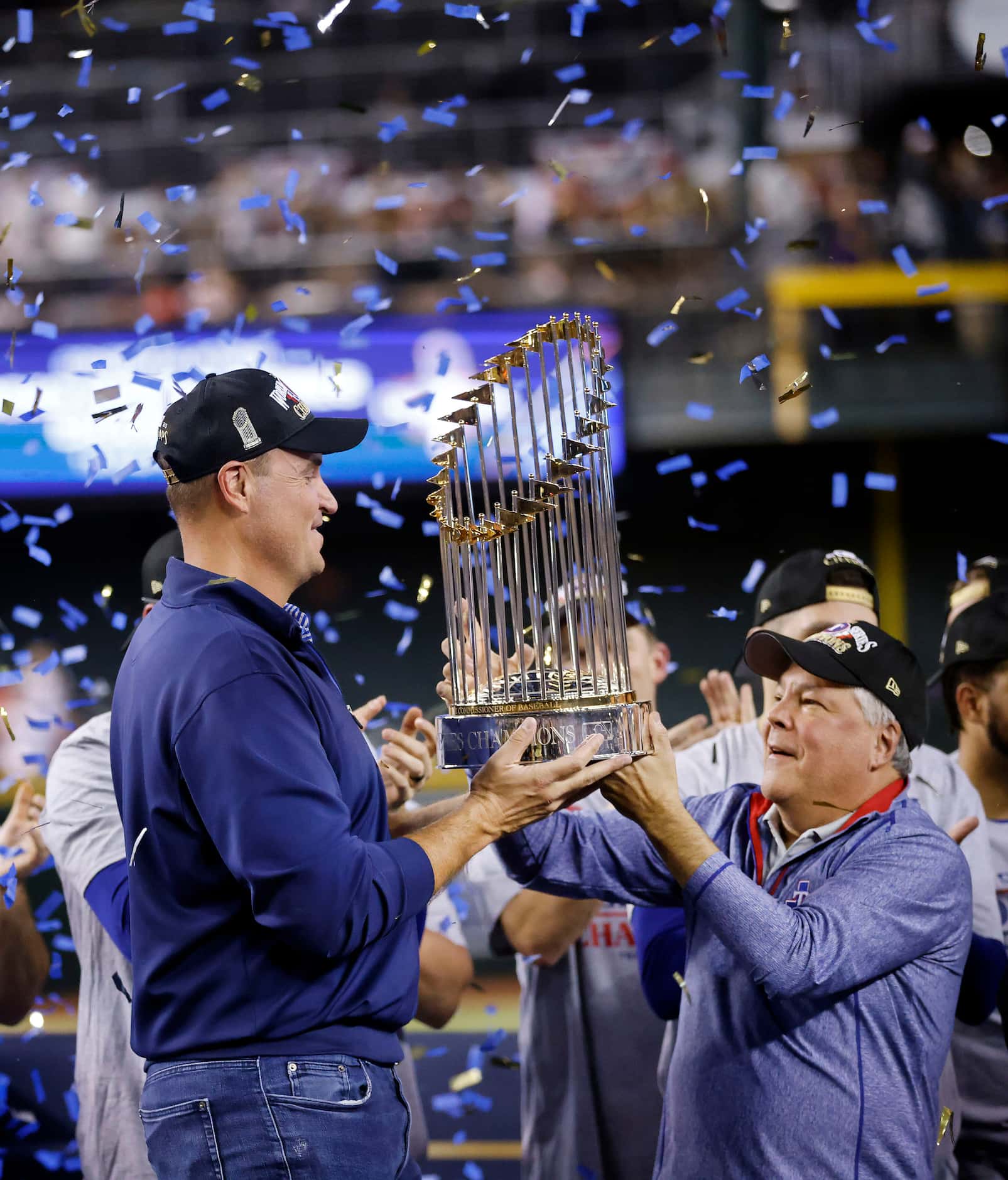 Texas Rangers general manager Chris Young (left) is handed the World Series trophy by...