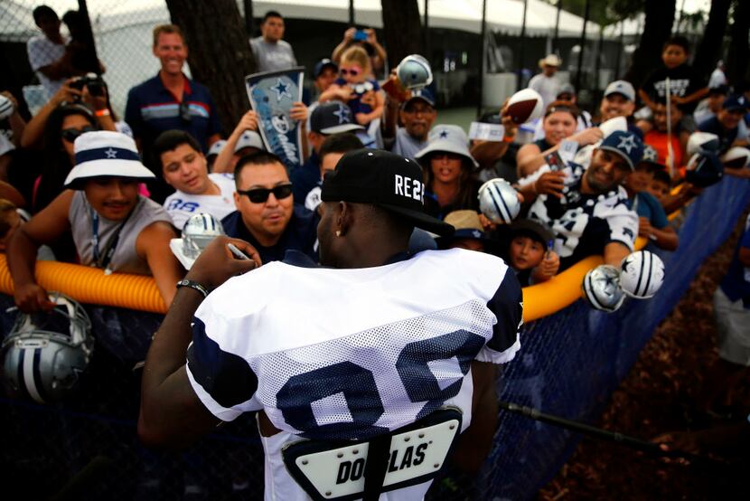 Dallas Cowboys wide receiver Dez Bryant (88) signs autographs following afternoon practice...