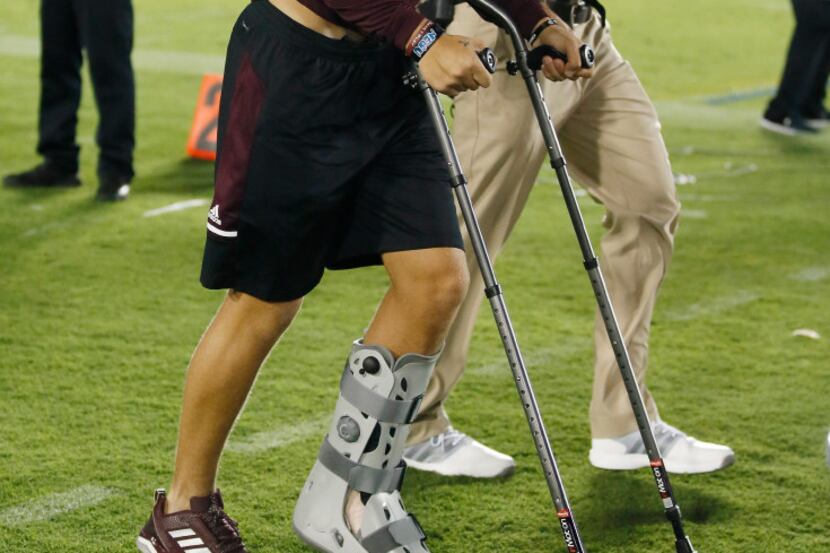Texas A&M quarterback Nick Starkel with crutches returns to the filed for the second half of...
