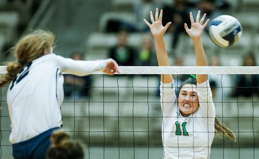 Flower Mound sophomore Angelique Cyr (12) spikes the ball as Southlake Carroll senior...