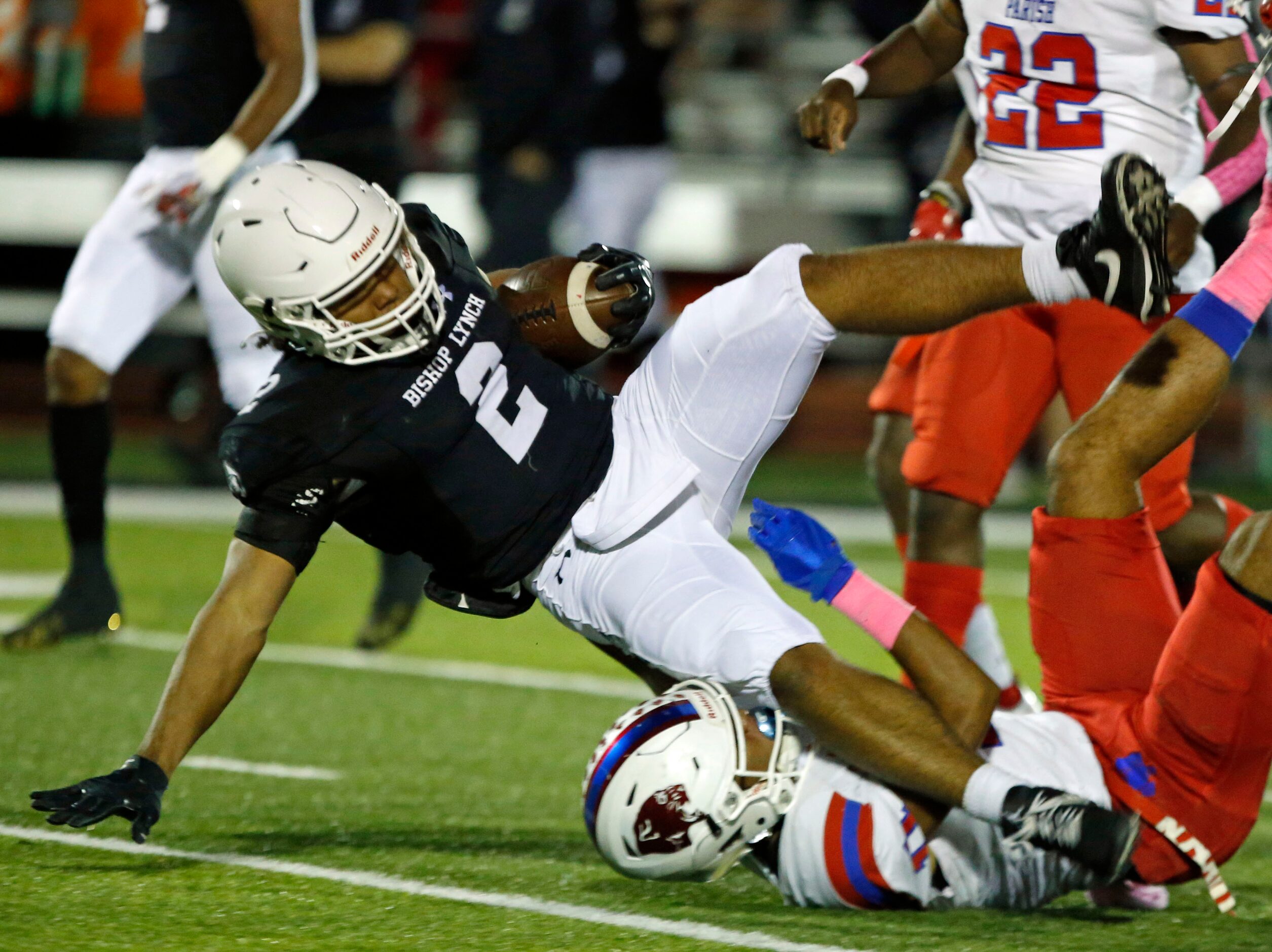 Bishop Lynch RB Isaiah Schmidtke (2) is tripped up by a Parish Episcopal defender during the...